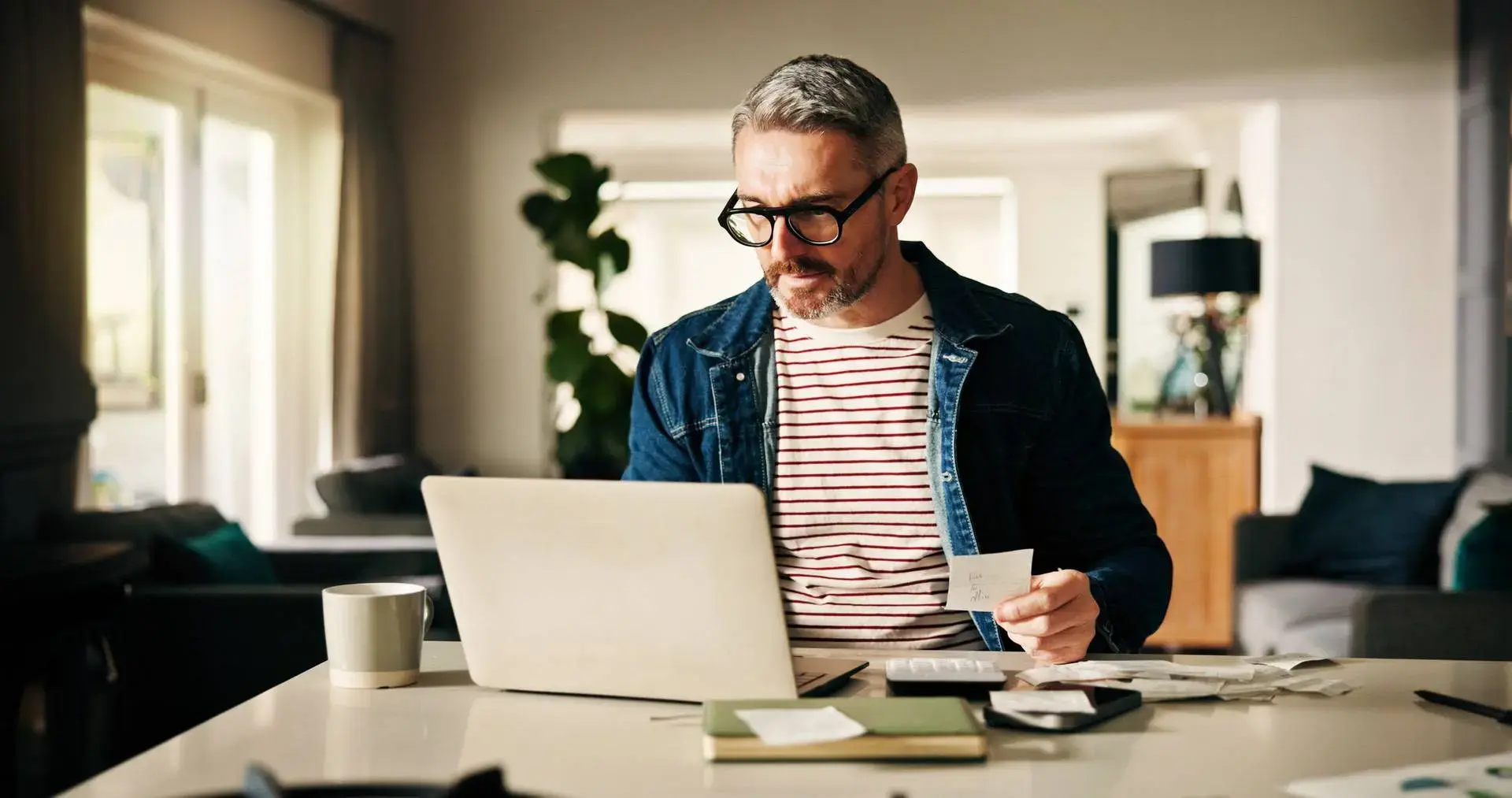 Man sitter vid datorn och räknar personlig budget. Kalp - Kvar att leva på kalkylering