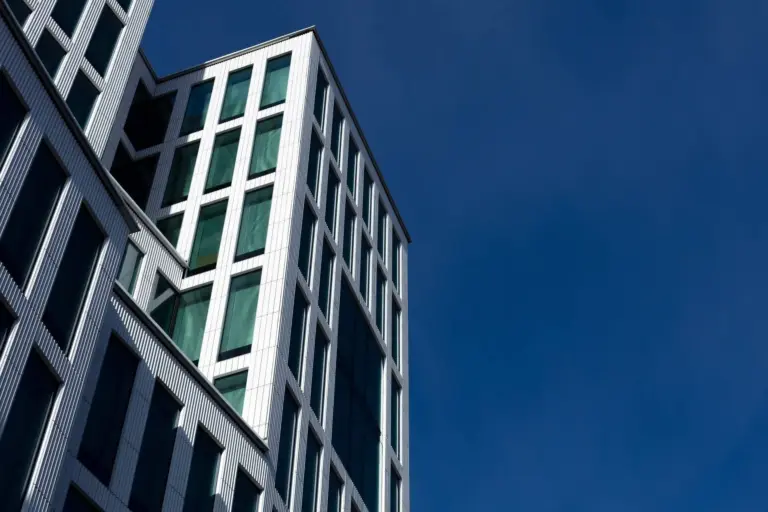 Modernt kontorshus fotograferat nedifrån mot blå himmel
